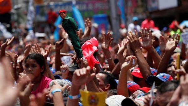 Supporters of Venezuela's President Nicolas Maduro holding a doll depicting Venezuela's late President Hugo Chavez, attend a campaign rally Charallave.