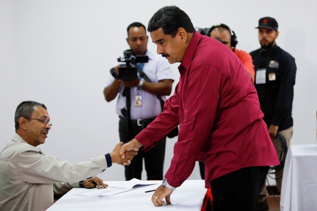 Venezuela's President Maduro greets a worker at a polling station in Caracas during the May 20 elections.