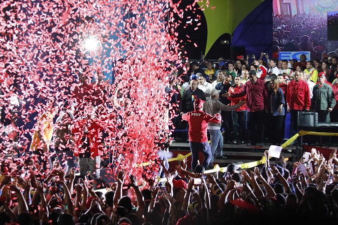 Confetti falls as supporters walk up to greet Venezuela's President Nicolas Maduro (center, R, in red) during a gathering after the results of the election were released, outside of the Miraflores Palace in Caracas, Venezuela, May 20, 2018.