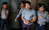 Detained Reuters journalist Wa Lone leaves the court handcuffed, in a police vehicle, after a hearing in Yangon, Myanmar May 21, 2018.