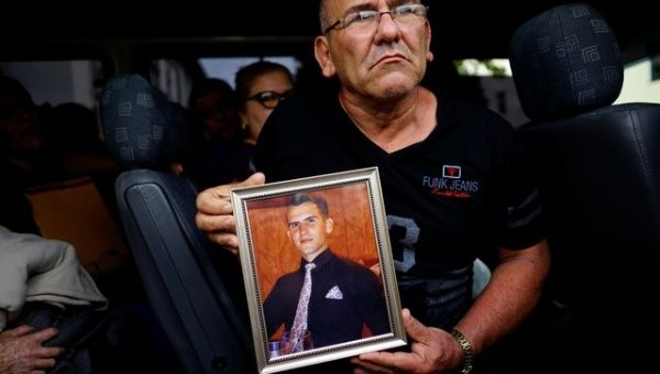 Mario Santos shows a picture of his late son Carlos Santos, who was killed in the Boeing 737 plane crash, as he leaves a funeral parlor in Havana.