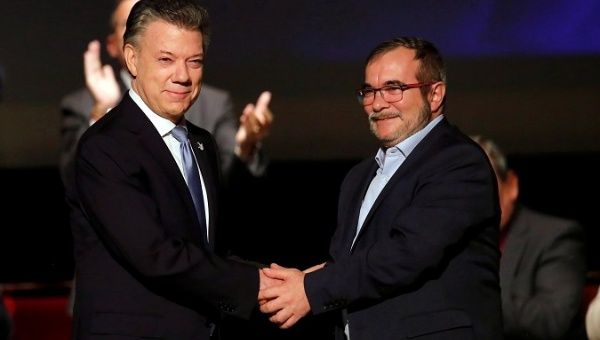 Colombia's President Juan Manuel Santos and FARC leader Rodrigo Londono shake hands after signing a peace accord in Bogota, Colombia November 2016.