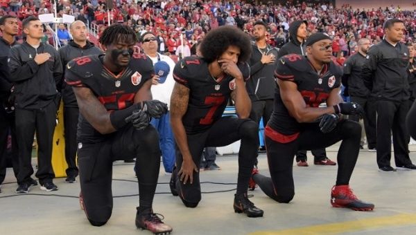 San Francisco 49ers Eli Harold (58), Colin Kaepernick (7) and Eric Reid (35) kneel in protest during the playing of the national anthem before an NFL game.