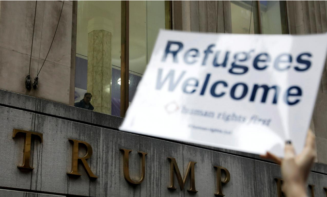 FILE PHOTO: Protesters gather outside the Trump Building at 40 Wall St. to take action against America’s refugee ban in New York City, U.S., March 28, 2017.