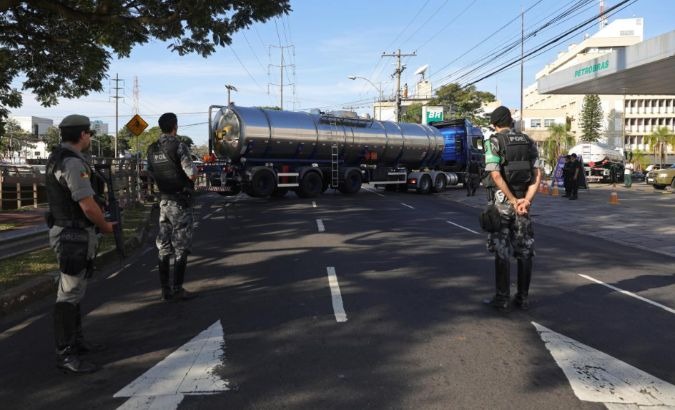 Policemen take position as a fuel truck arrives at a gas station in Porto Alegre, Brazil.