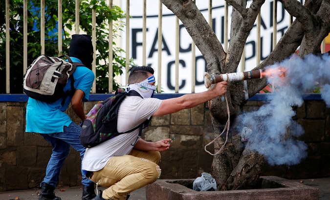 Nicaraguan protester fires homemade mortar at riot police.