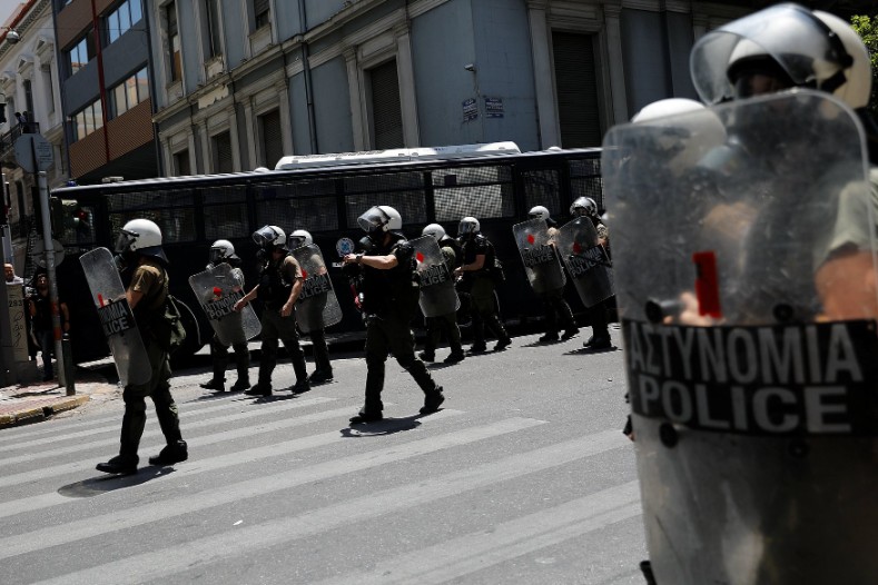 Riot police guard the Hellenic Business Federation offices during a demonstration marking a 24-hour general strike against planned austerity measures.
