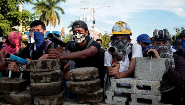 Demonstrators stand behind a barricade during clashes with riot police during a protest against Nicaragua's President Daniel Ortega's government in Managua, Nicaragua May 30, 2018. 