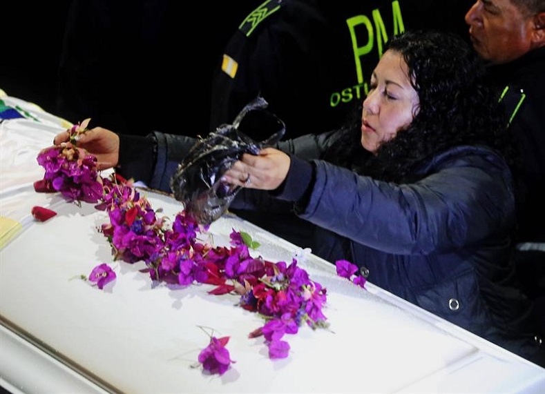 A woman throws flowers on Claudia's coffin during the wake on May 31, 2018, in the municipality of San Juan Ostuncalco, Quetzaltenango.