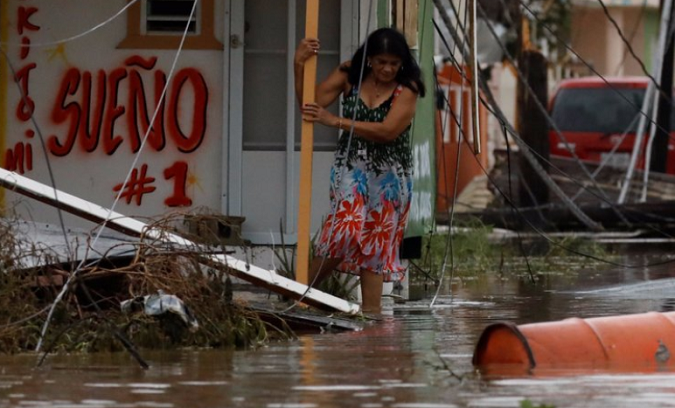 A woman tries to walk out from her house after it was hit by Hurricane Maria in Salinas, Puerto Rico, September 21, 2017.