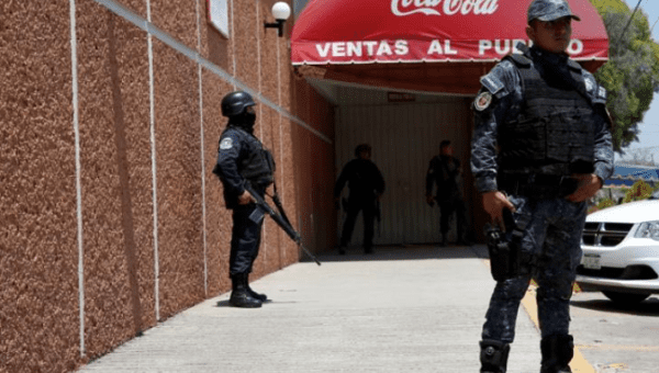 Police guard the Coca-Cola distribution plant after it closed due to violence in Ciudad Altamirano in Guerrero, Mexico, April 2018.