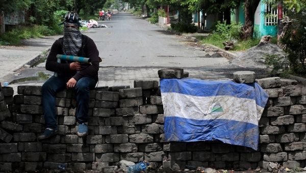 A man holding a homemade mortar sits on a roadblock in Managua, Nicaragua June 16, 2018. 