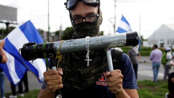 A demonstrator holds a homemade mortar during a protest against the government of Nicaragua's President Daniel Ortega, in Managua, Nicaragua June 17 2018.