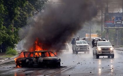 Riot police officers travel past a burning car during clashes with the anti-government protesters in Managua, Nicaragua May 28, 2018. 