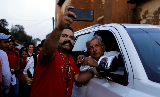 Leftist front-runner AMLO poses for a selfie with a supporter after a campaign rally in Michoacan. May 31, 2018.