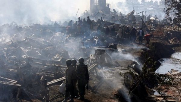 Traders and riot police are seen at scene of fire that gutted down the timber dealership of the Gikomba market in central Nairobi, Kenya June 28, 2018. 