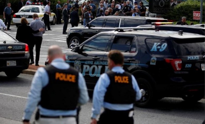 Law enforcement survey the scene after a gunman opened fire at the Capital Gazette newpaper, killing five and injuring others on June 28, 2018.