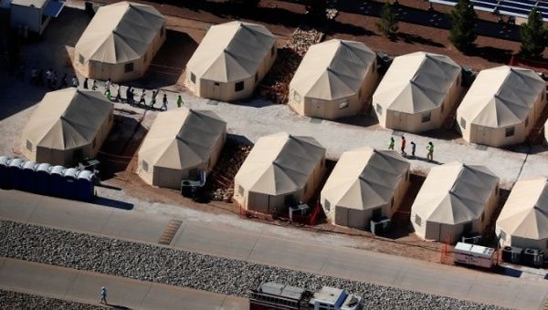 Children walk in single file between tents in a detention center next to the Mexican border in Tornillo, Texas, June 18, 2018.
