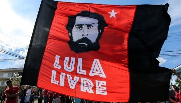 Supporters of former Brazilian President Luiz Inacio Lula da Silva hold a flag next to Federal police headquarters in Curitiba, Brazil, July 8, 2018. The flag reads: 
