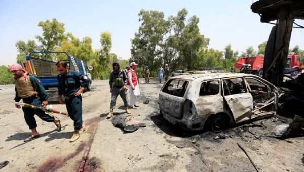 Afghan policemen inspect the site of a suicide attack in Jalalabad city, Afghanistan July 10, 2018. 