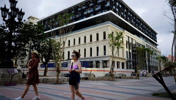 Tourists pass by a hotel under construction at the Paseo del Prado boulevard in Havana, Cuba, May 9, 2018. Picture taken on May 9, 2018. 