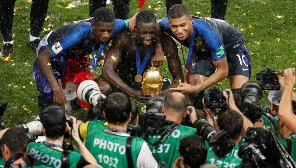 France's Ousmane Dembele, Benjamin Mendy and Kylian Mbappe with the trophy as they celebrate winning the World Cup.
