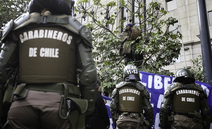 Riot police on standby during a Mapuche protest in support of imprisoned community members in Chile, July 3, 2018
