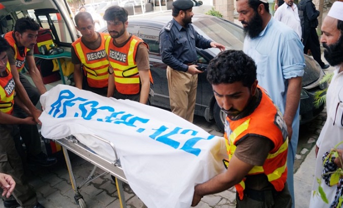 Rescue workers move the body of Ikramullah Gandapur, a candidate of the Pakistan Tehreek-e-Insaf (PTI), or Pakistan Justice Movement.