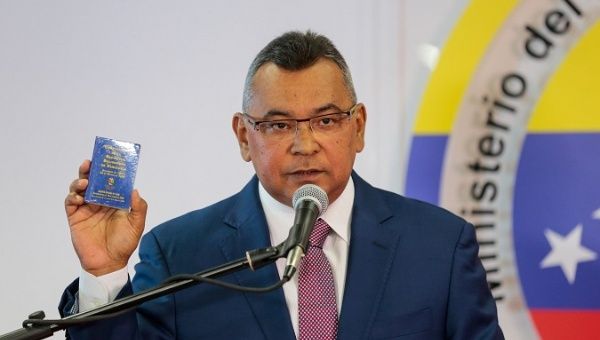 Venezuela's Interior and Justice Minister Nestor Reverol holds a copy of the National Constitution while he speaks during a news conference in Caracas.
