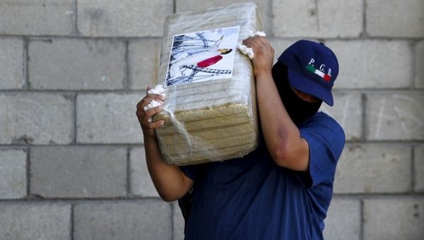 An agent with seized marijuana at a passageway attributed to Joaquin 'El Chapo' Guzman's cartel in Tijuana, 2015. 