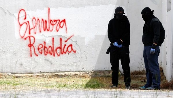 Demonstrators by graffiti that reads 'sowing rebellion' in an anti-government protest at the National University in Bogota, Colombia.