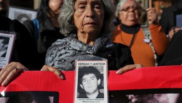 A human rights activist holds an image of a missing person during a protest against the decision of the Supreme Court to grant parole to human right abusers during Chilean dictatorship, in Santiago, Chile August 13, 2018.