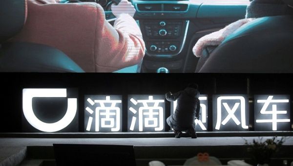  A man is seen in front of a Didi sign before a promotional event of its Hitch service in Beijing, China January 24, 2018