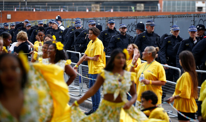 Police officers look on as revellers take part in the Notting Hill Carnival