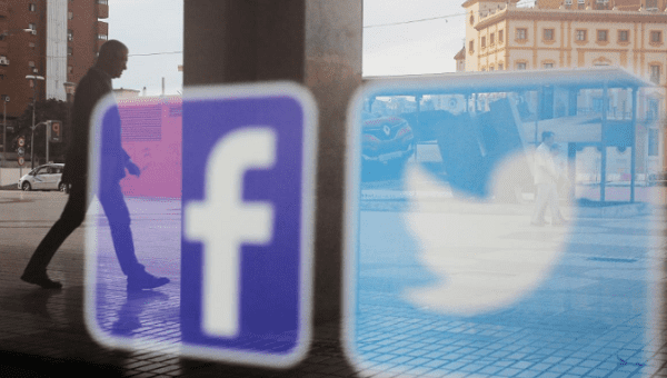 Facebook and Twitter logos are seen on a shop window in Malaga, Spain, June 4, 2018.