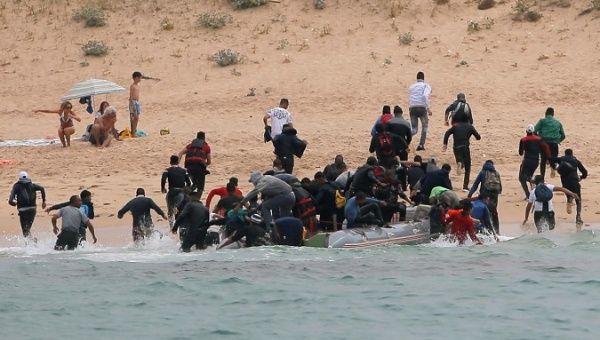 Migrants disembark from a dinghy at 