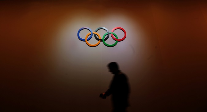 A man walks past the Olympic rings as he walks out of the 133rd IOC session in Buenos Aires.