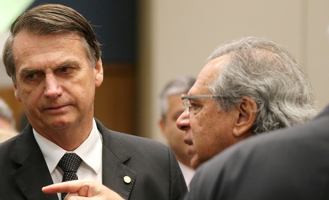 Jair Bolsonaro listens to economist Paulo Guedes before a lunch with businessmen at the Federation of Industries of Rio de Janeiro headquarters.