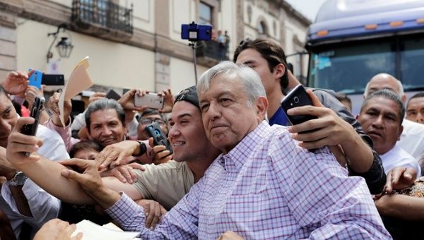 Mexico's President-elect Andres Manuel LopezObrador poses for a selfie with a man in a rally as part of a tour to thank supporters for his victory in the July 1 election, in Morelia