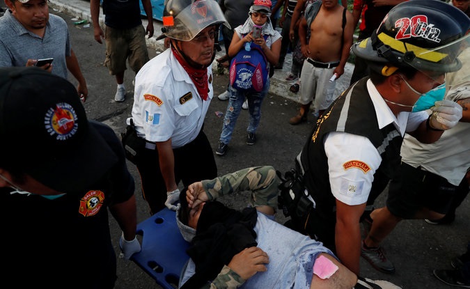 An injured man part of a caravan of thousands of migrants from Central America en route to the U.S, is been helped, during a clash with the Mexican Police after they pull down the border gate with the intention to carry on their journey, in Tecun Uman, Guatemala, October 28, 2018.