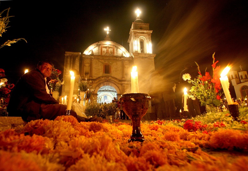 Mexico’s cemeteries are painted bright yellow and orange as relatives place them above the tombs of their loved ones. 