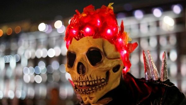 A man wears a mask as he takes part in a Catrina event ahead of the Day of the Dead, at Zocalo Square in Mexico City, Mexico October 31, 2018. 