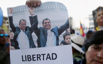 A supporter of Ecuador's former President Rafael Correa holds a picture of him and Vice President Jorge Glas, protests outside the Supreme Court in Quito.
