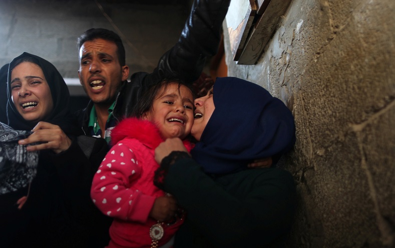 The daughter of Khaled Qwaider, who was killed in an Israeli air strike, cries as she is carried during his funeral.