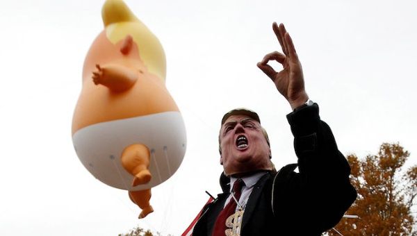 People take part in a protest against US President Donald Trump, as part of the commemoration ceremony for Armistice Day.