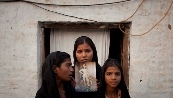 FILE PHOTO: The daughters of Pakistani Christian woman Asia Bibi pose with an image of their mother while standing outside their residence in Sheikhupura Pakistan 12/11/2018 09:35.