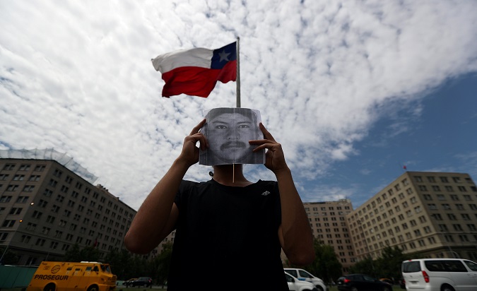 A demonstrator holds up an image of Camilo Catrillanca, an indigenous Mapuche man who was shot and killed by police in his town of Temucuicui. Santiago, Chile, November 22, 2018.