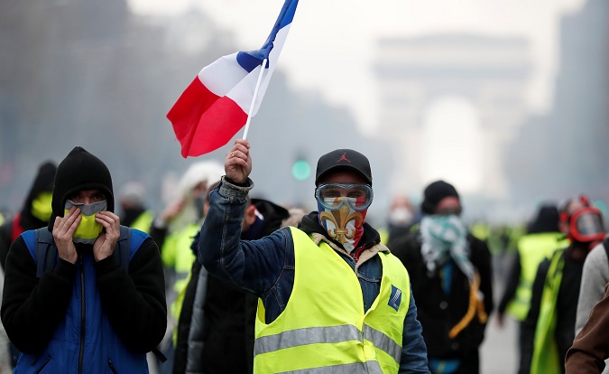 Masked protesters wearing yellow vests, a symbol of a French drivers' protest against higher fuel prices, take part in a demonstration on the Champs-Elysees in Paris, France, November 24, 2018.