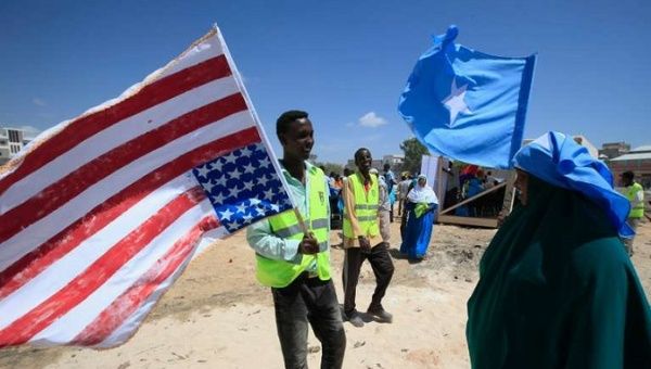 A man holds up an American flag and a woman holds a Somali flag in Mogadishu, Somalia, in January 2013. 
