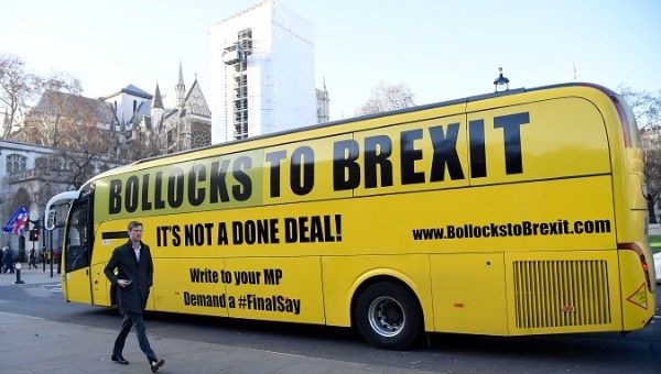A bus with anti-Brexit slogans parked in front of the British Parliament. 